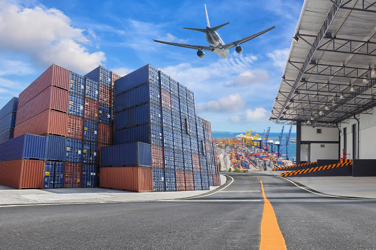 Airplane flying over a facility that holds shipping containers